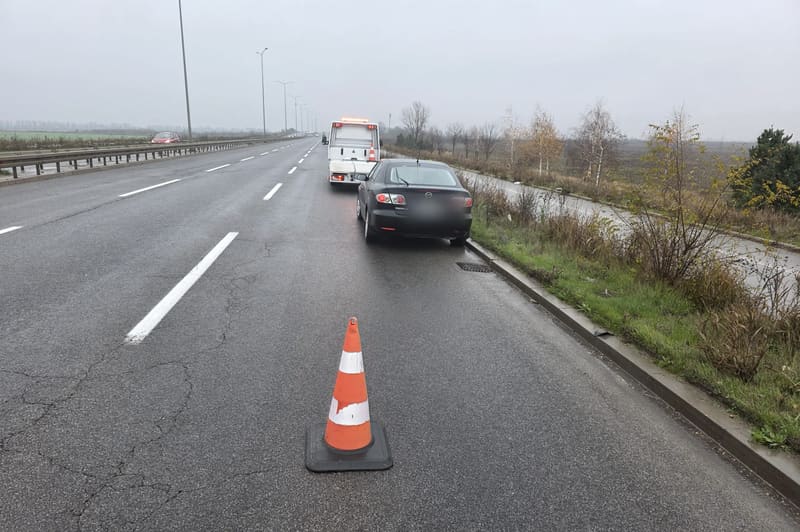 Automobil zaustavljen na ivici puta, iza njega saobraćajna kupa
