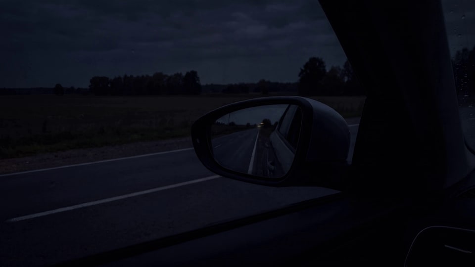 Noću, iz vozačevog sedišta: u levom retrovizoru srebrni šlep Deki Cars sa upaljenim narandžastim svetlom na uzglavlju dolazi i staje iza automobila.